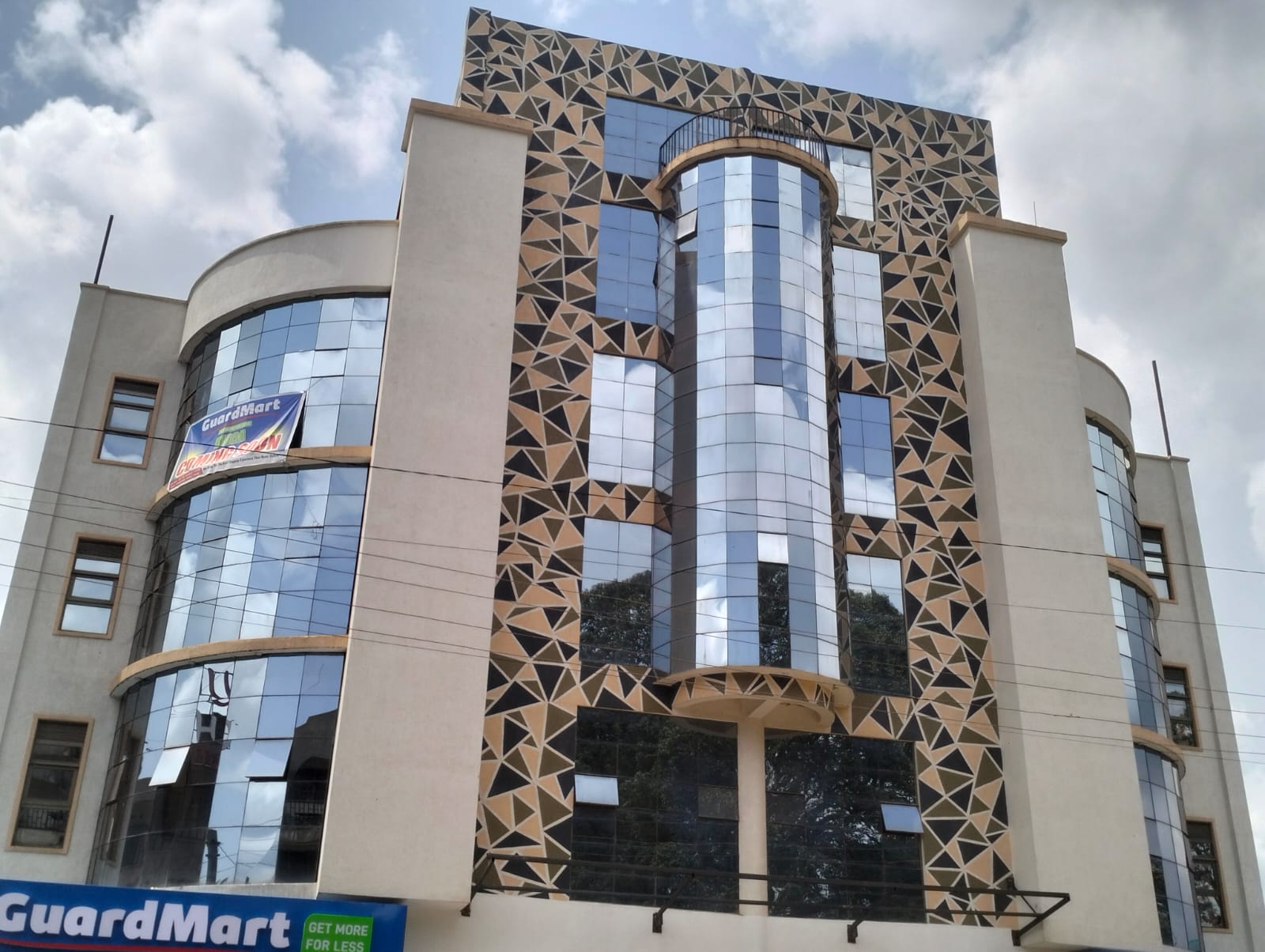 The glass and stone facade of KampDavid Mall in Kisii